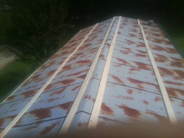 Rusted metal roof panels with new wood purlins before replacement — Storm Damage Roof Repair in New Castle by Roofing Brothers