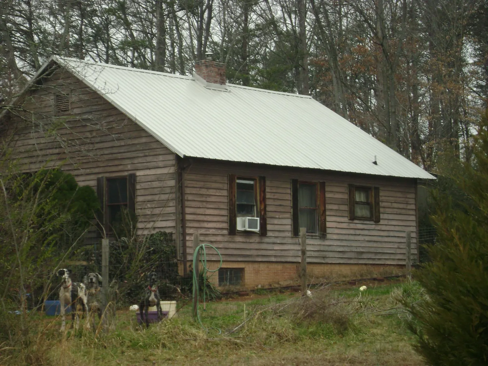 White metal roof on an old wood sided farmhouse, from a Asphalt Shingle Roof Repair job in New Castle